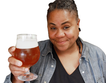 Headshot of Dr. J Jackson-Beckham from the torso up holding a tulip glass of beer.